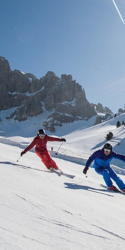 Coppia di giovani sciatori davanti al massiccio Dolomitico | © Ph. H.Wiesthaler